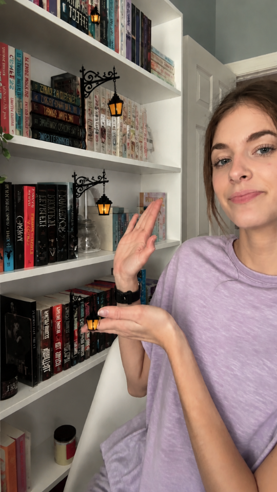 Collector showing two lantern bookends on her white bookshelf