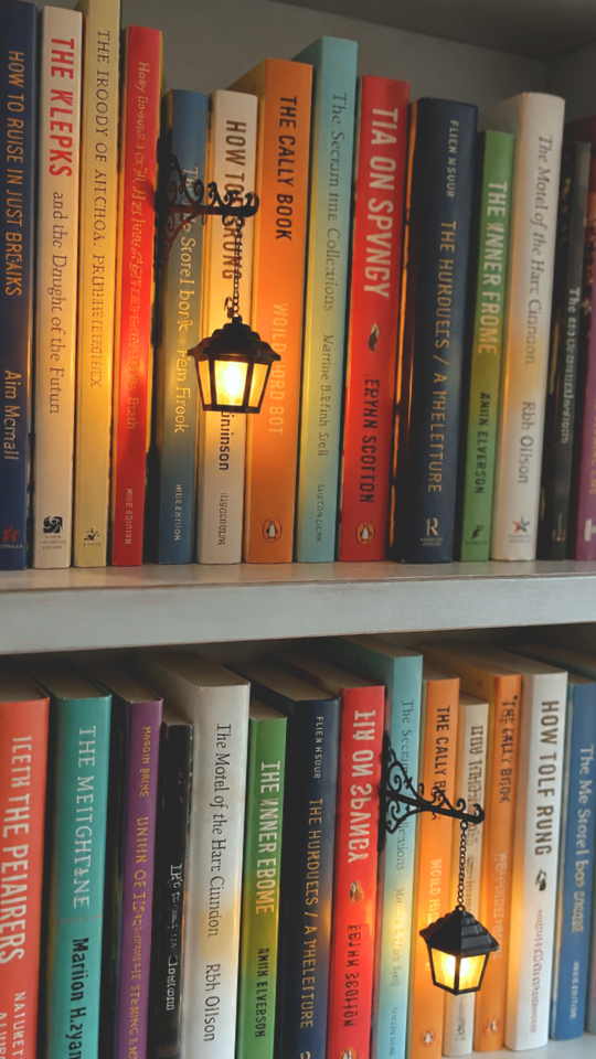 Close-up of lanterns glowing between book spines